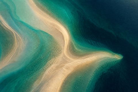 Aerial abstract of pale sandbars and turquoise shallows