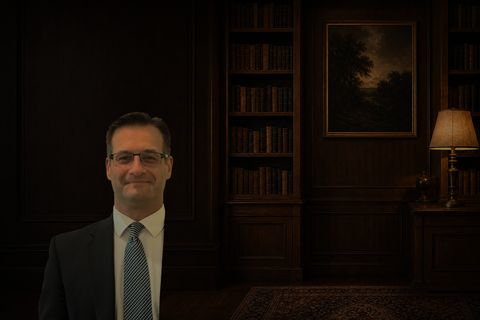 Bryan P. Filson seated in a wood-paneled study, photographed in warm lamplight